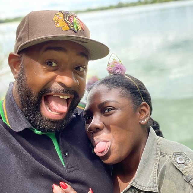 Bear and Carlene pulling faces with their tongues out by a lake